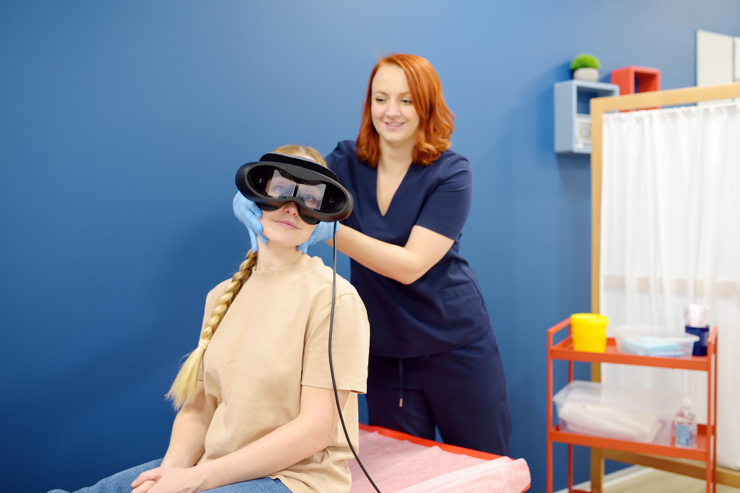 Neurologist performing positional testing of patient using videonystagmography . VNG testing uses goggles with infrared cameras to track eye movements, and can help to determine if the patient is experiencing an abnormality from the peripheral